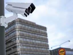AXIS P1387-LE from AXIS COMMUNICATIONS - mounted on pole with office building in background