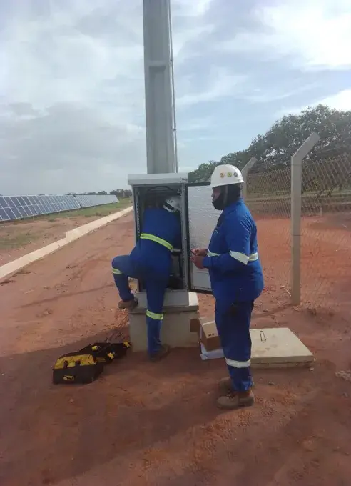 Técnicos configurando painel elétrico em usina solar