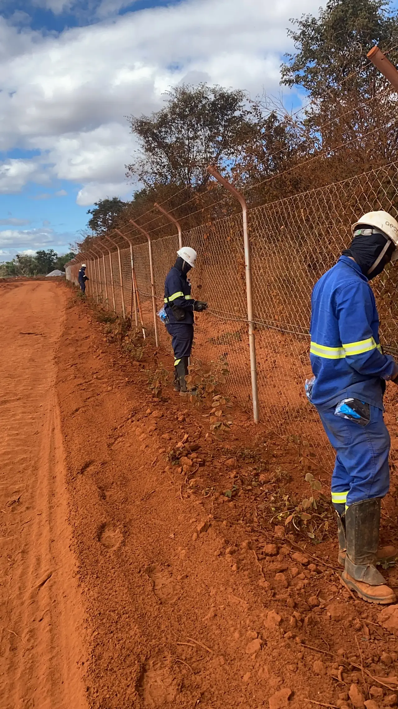 Equipe de campo inspecionando cerca perimetral em área remota